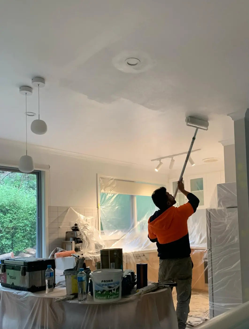 Painter applying a fresh interior ceiling finish